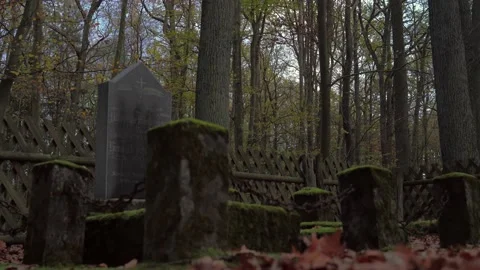 Zoom out and zoom in on old gravesite with mossy gravestones and rusty chains Stock Footage 134879122