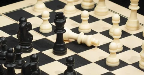 Zoom out of a black king chess piece check mate over a chess board Видео 328319752