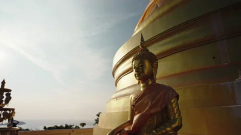 Zoom out camera moves from the face of golden sitting Buddha statue on the Video stock 239517896