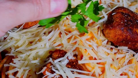 Zoom out of chef hand placing fresh parsley garnish on spaghetti Stock Footage 324307125