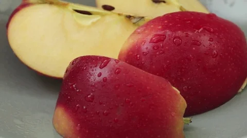 Zoom out on cut pieces of red apple on grey plate Stock Footage 80375318