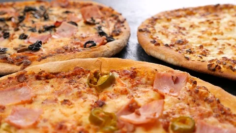 Zoom out dolly shot on three pizzas Stock Footage 84777234