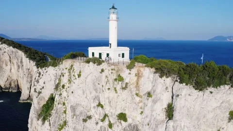Zoom out drone shot of white lighthouse on a cliff. Stock Footage 158325425