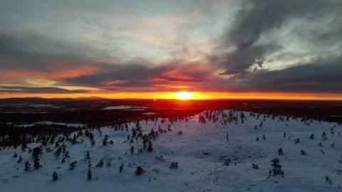 Zoom out drone view of winter sunset over snowy forests and mountains in Lapland Stock Footage 301329648