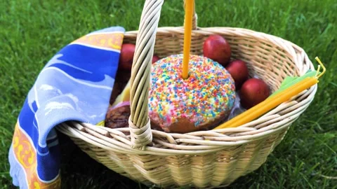 Zoom out of Easter cake, eggs and candles in basket on the green meadow Stock Footage 274842930