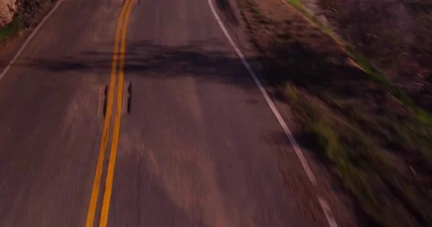 Zoom out of empty winding road from moving car Stock Footage 136340733