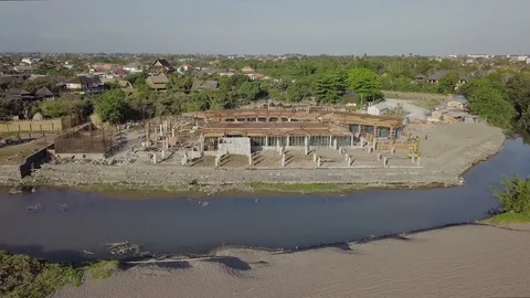 Zoom out footage from the construction side towards the ocean aerial footage Stock Footage 100692760