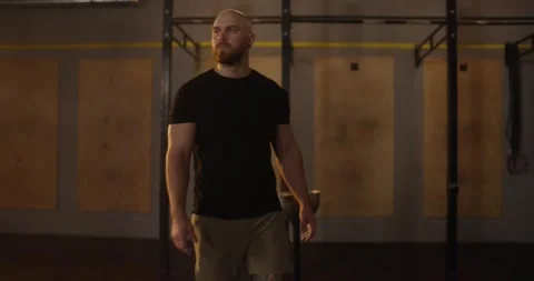 Zoom Out guy athlete in black t-shirt claps hands with sports chalk and walks Stock Footage 313424166