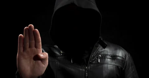 Zoom out of a hooded hacker man with his right hand making a stop signal Video stock 328319778