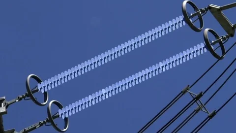 Zoom out: Insulators on a power pole, power towers, blue sky, movin cloud Stock Footage 76767069