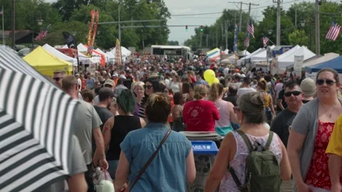 Zoom out on large crowd at summer festival revealing food courts Stock Footage 240074251