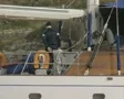 Zoom out from man standing on boat using exercise equipment to bay SD Footage