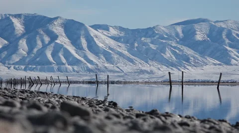 Zoom out from mountain to rocks in foreground over glassy water Salt Lake City Stock Footage 58797689