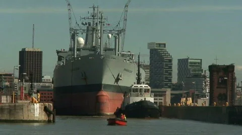 Zoom out of RFA Orangeleaf being towed into dock Stock Footage 67161