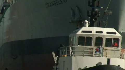 Zoom out of RFA Orangeleaf being towed into dock Stock Footage 67190