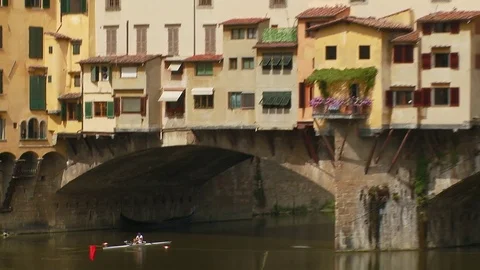 Zoom out from rowing boat under the Ponte Vecchio Florence, Italy Stock Footage 74799527