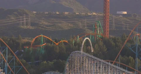 Zoom out of Six Flags Magic Mountain Roller Coasters from a distance Stock-Footage 201025997