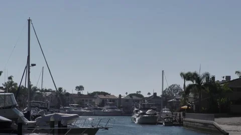 Zoom out on a Small finger in the harbor oceanfront homes with their yachts a Stock Footage 67679807
