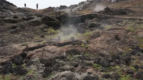 Zoom out from smokey lava field in Iceland with people in the background 스톡 동영상 245911341