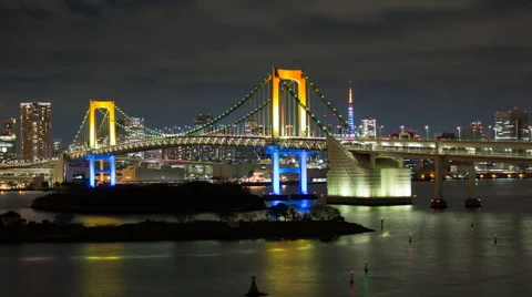 Zoom out time lapse of the Rainbow Bridge at night as seen from Odaiba Stock Footage 50503879
