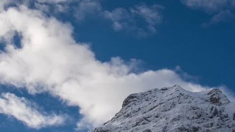 Zoom-out timelapse shot of clouds running over snowy peaks of the Julian Alps Video stock 89836164