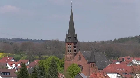 Zoom out from the tower of the old catholic church of rural village Otterbach Stock Footage 76763124