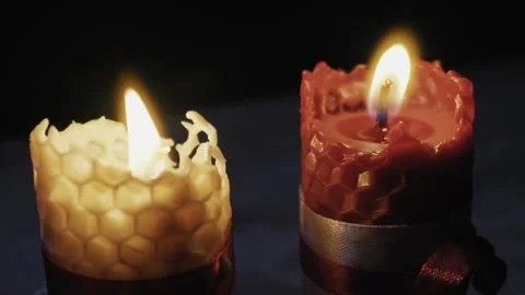 Zoom Out of Two Burning Beeswax Honeycomb Candles on Dark Background Video stock 330274536