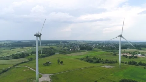 Zoom out from two wind power turbines. Cloudy sky. Drone footage Stock Footage 133001362