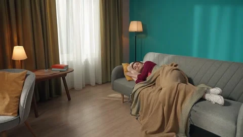 Zoom out video capturing a redhead woman peacefully sleeping on the couch while Stock Footage 252388646