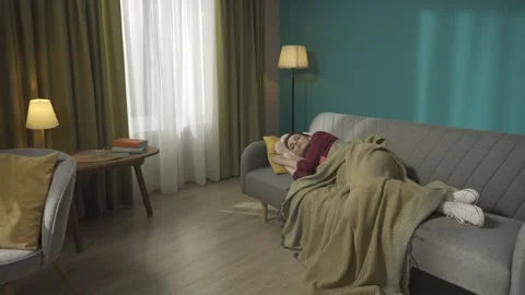 Zoom out video capturing a redhead woman peacefully sleeping on the couch while Stock Footage 252391436