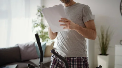 Zoom out video of man exercising and working at home. Stock Footage 128869686