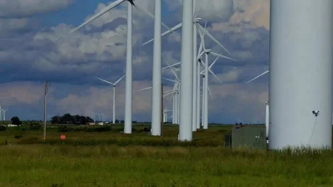 Zoom out while looking through dozens of spinning wind turbines on Texas prairie Vídeo Stock 157366693