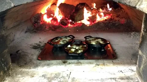 Zoom in on a pan full of fried snail escargots, in a wooden heated oven, at a Stock Footage 58303013
