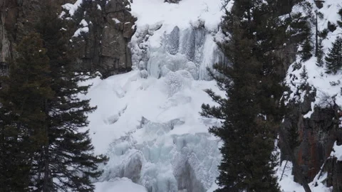 Zoom in on a partly frozen over undine falls at yellowstone in winter Stock Footage 137492353