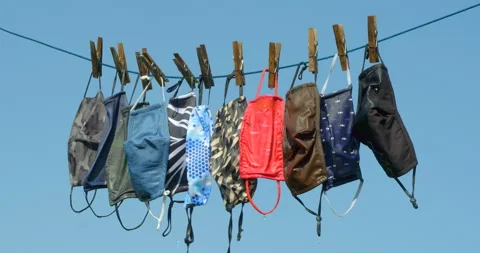 Zoom into re-usable face masks drying in a breeze. Vídeo Stock 139310757