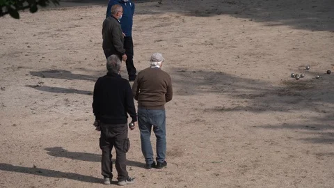 Zoom in rear view, a group of elderly men playing petanque in France Stock Footage 130386948