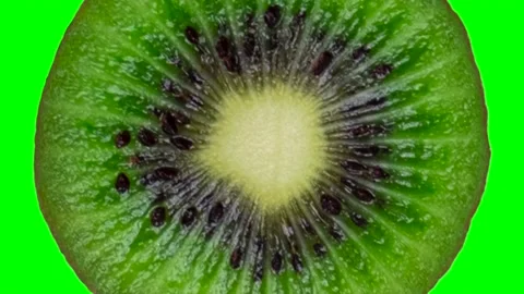 Zoom into rotation of half or slice of kiwi in minimal motion on green chroma Stock Footage 205515181