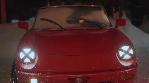 Zoom in shining front car headlights of red Alfa Romeo Spider, snow falling Stock Footage 197455309
