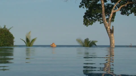 Zoom in shoot of man at edge of infinity pool. Video stock 28837445