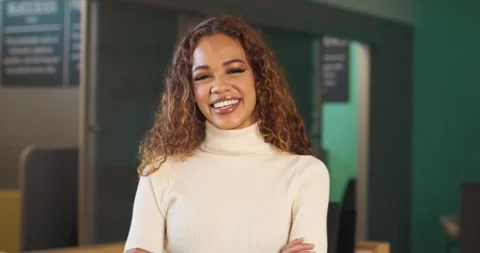 Zoom in shot of beautiful young front desk receptionist, arms folded, laughing Stock Footage 244538495
