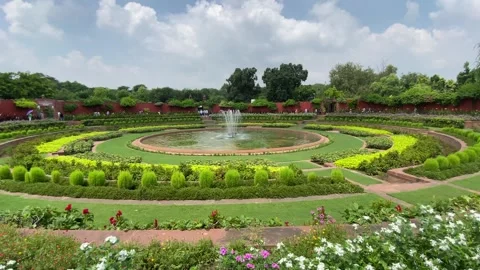 Zoom in shot of Circular shape green garden with water fountain in center Video stock 248590670