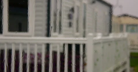 Zoom Shot of rain on a static caravan window with static caravans in background Stock Footage 346814990