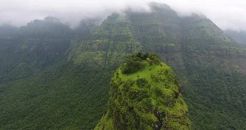 Zoom in shot of a structure on top of a mountain in a lush green forest Stock Footage 117004300
