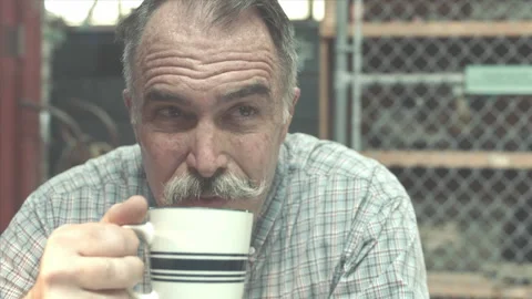 Zoom-in shot of a supervisor drinking coffee at table, 2000s - Reenactment Stock Footage 243738044