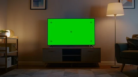 Zoom In Shot of a TV with Horizontal Green Screen Mock Up. Evening Living Room Stock Footage