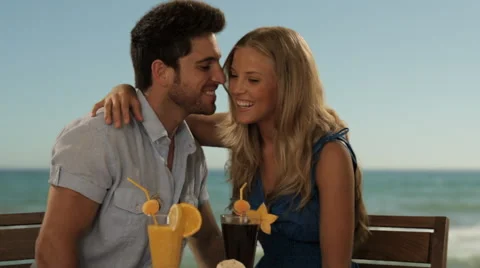 Zoom in shot of young couple having drinks by sea Stock Footage 43679417