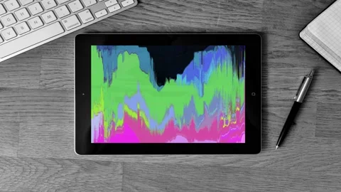 Zoom in a tablet on a work desk, glowing glitch original animation on screen Stock Footage 119293594