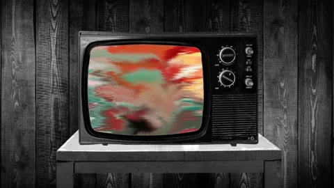 Zoom in then fixed shot on 70s television, color deformations, static tv bug Stockbeeldmateriaal 119434909