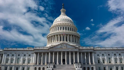Zoom in time lapse cinemagraph of the US Capitol set against a blue sky with Video stock 128435077