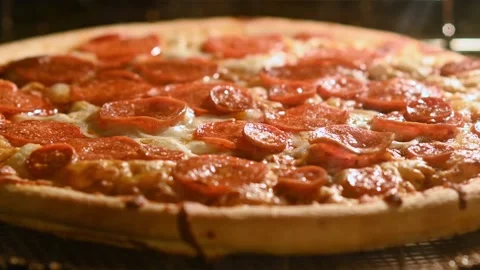 ZOOM IN Time lapse of pepperoni pizza cooking in an oven Stock Footage 144258079